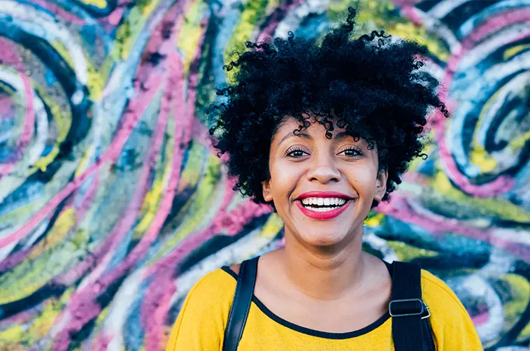 A confident woman smiling as part of her New Year's resolution for better mental health and personalized therapy with Turnwell.
